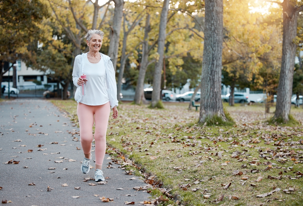 Older woman on a walk outside to promote circulation and vein health.
